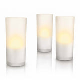 Three frosted glass taper candles with warm yellow LED light glowing inside