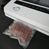 A vacuum sealer machine sealing a  plastic bag filled with beans